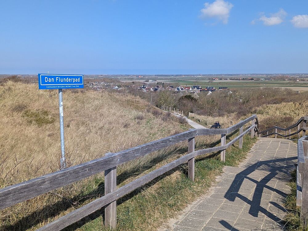 Een wandelpad met houten hek door de duinen bij Zoutelande